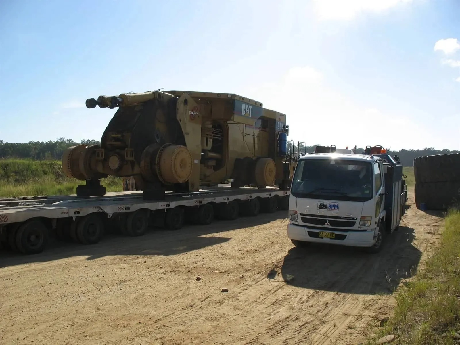 Buckley's Plant Maintenance service truck transporting a CAT 994 loader